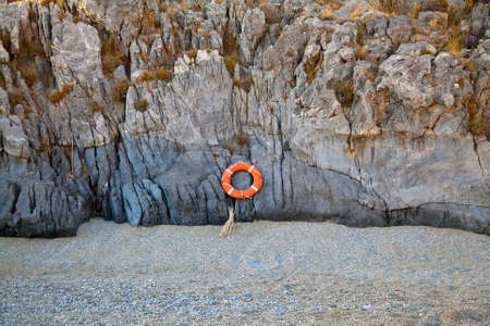 lifebuoy attached to rockの写真素材