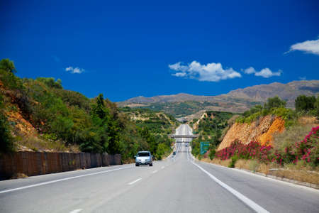 country road leading up to mountains in Crete, Greeceの写真素材