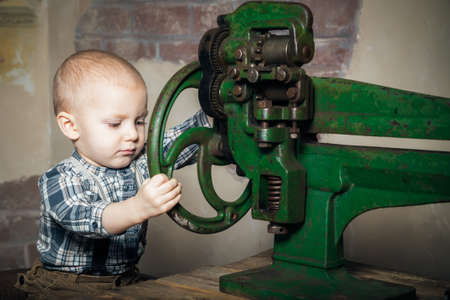 little boy turning the machineの写真素材