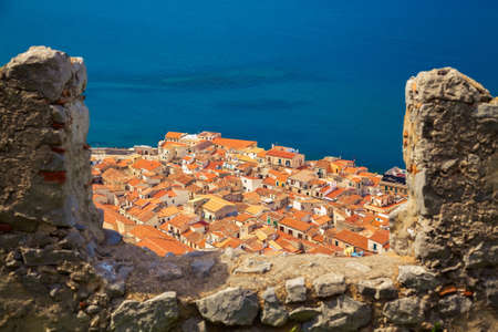 orange roofs of Cefalu old houses through the bastion