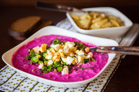traditional lithuanian cold beetroot soup with greens and eggs, served with hot potatoesの写真素材