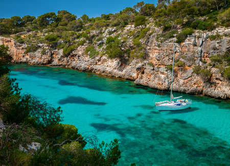 small yacht floating in clear azure sea, Mallorca, Spain