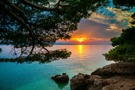 sun setting over the Adriatic sea in Brelaの写真素材