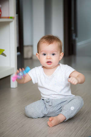 funny little baby girl shaking the rattle