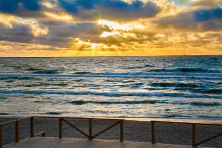 sun is shining through clouds on a Baltic seaの写真素材
