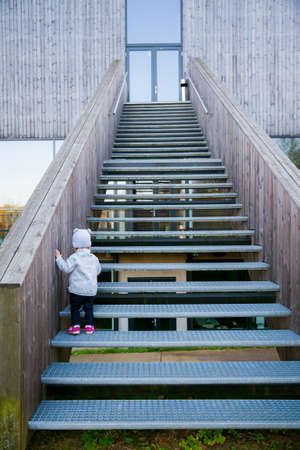 little baby girl climbing upstairs by herselfの写真素材