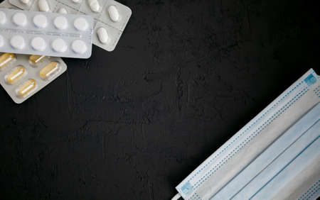 Black background with medicines and protective masks. Illness concept. Copy-space, flat layの写真素材