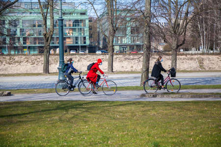 Vilnius, Lithuania - March 27, 2020: Three women cyclists riding their bikes wearing protective masks because of the Coronavirus outbreak.のeditorial素材