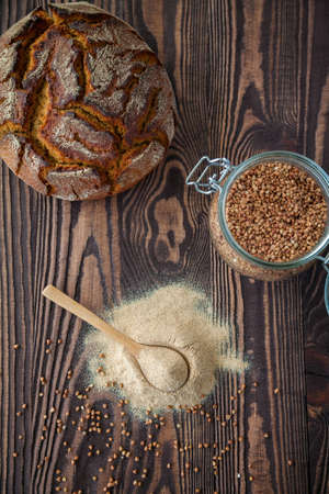 Flat lay with buckwheat flour and bread on a wooden background. Alternative flour. Gluten free dieting. Healthy eating and baking.の写真素材