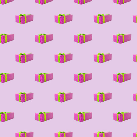 Gift pattern. Pink seamless background. Symmetrical arrangement of presents in polka dot boxes with ribbon bowsの写真素材
