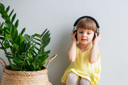 Cute little girl with headphones listening to musicの写真素材