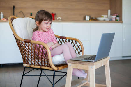 Little girl video-chatting with her grandparents using laptopの写真素材