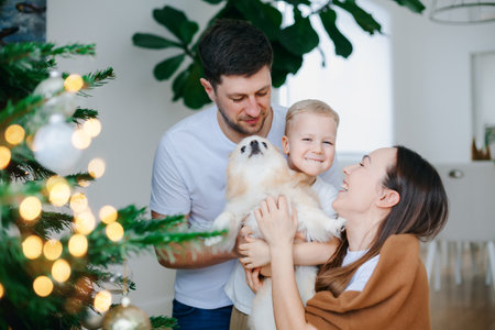 Portrait of a beautiful happy family with dog hugging near the Christmas treeの写真素材