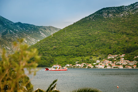 Beautiful view on Boka Kotor Bay and regular passenger ferry from Lepetane to Kamenari in Montenegroの写真素材