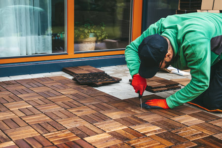 A man bringing the space to life with wooden flooring on the terrace at home
