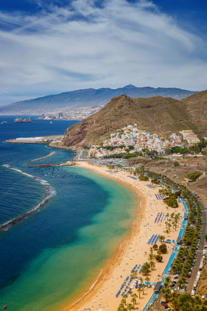 A relaxing aerial scene at Las Teresitas, with sun loungers, clear waters, and mountain views, showcasing Tenerife's beach appealの写真素材