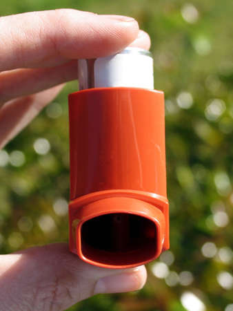 Hand holding an asthma inhalerの写真素材