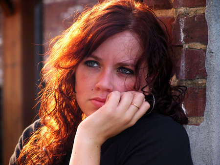 Portrait of a young woman with sunlit hair and sad expression