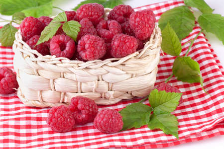 raspberries with leaves in basket