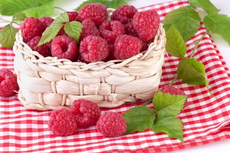 raspberries with leaves in basketの写真素材