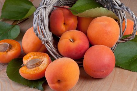 Fresh apricot with leaves on wood backgroundの写真素材