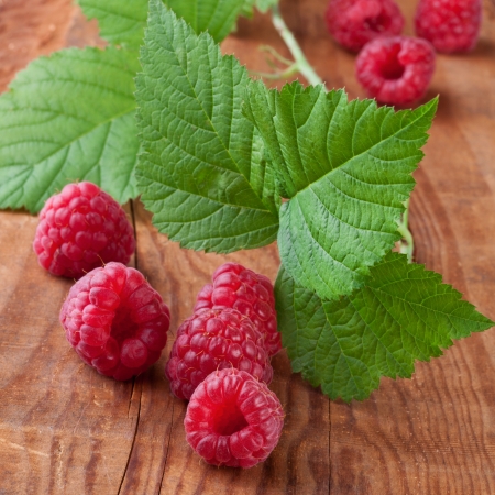 raspberries with leafs on wooden backgroundの写真素材