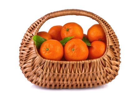 tangerines with leaves in beautiful basket isolated on whiteの写真素材