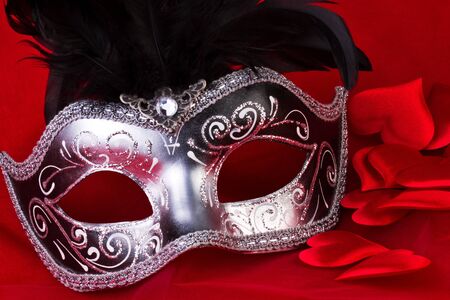 venetian mask and hearts on red backgroundの写真素材