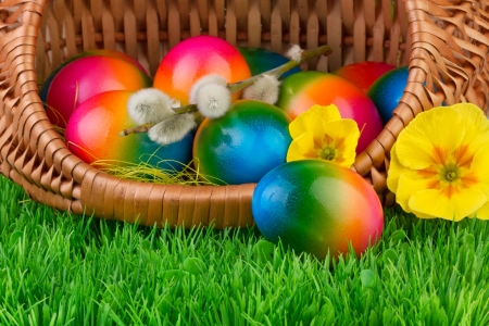 Easter eggs in wicker basket on green grassの写真素材