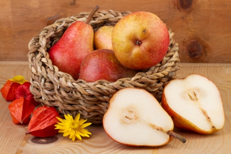 fresh pears in basket on wooden backgroundの写真素材