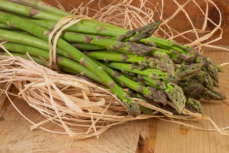 bundle of green asparagus on wooden tableの写真素材