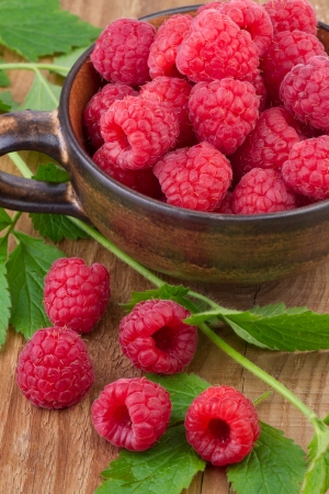 fresh raspberry in a cup on wooden tableの写真素材