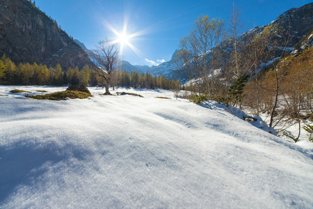 A scenic landscape with snow capped mountains in the late autumn seasonの写真素材