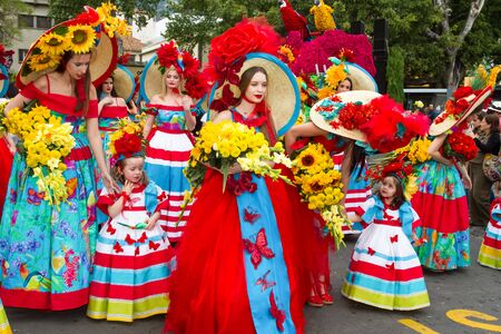 FUNCHAL, MADEIRA - APRIL 20, 2015: Young women and children with colorful floral costumes at the Madeira Flower Festival, Funchal, Madeira, Portugalのeditorial素材
