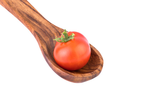 tomato on wooden spoon close upの写真素材