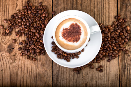 Coffee cup Cappuccino on old wooden table. Heart shape foam, top view.の写真素材