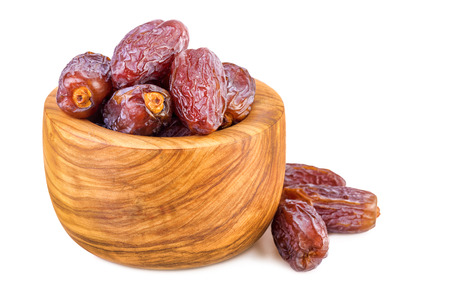 sweet dates in olive wood cup on whiteの写真素材