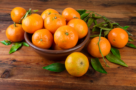 Mandarins tangerines in brown ceramic bowlの写真素材