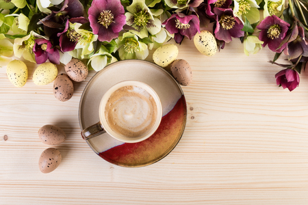 Coffee concept with spring flowers Easter eggs on light wood. Top view, copy spaceの写真素材