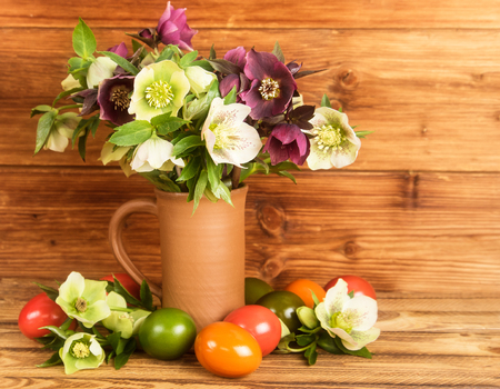 Rustic Easter still life. Easter eggs, blossoms Hellebore flowers in rustic jug.の写真素材
