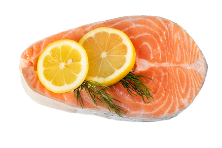 Salmon fish steak raw uncooked with lemon slice on white. Flat lay, top viewの写真素材