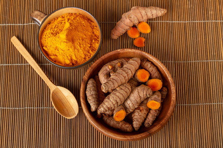 Turmeric roots and powder on bamboo napkin. Top view, overhead shotの写真素材