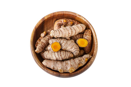 Turmeric roots in wooden bowl isolated on white. Top view overhead shotの写真素材