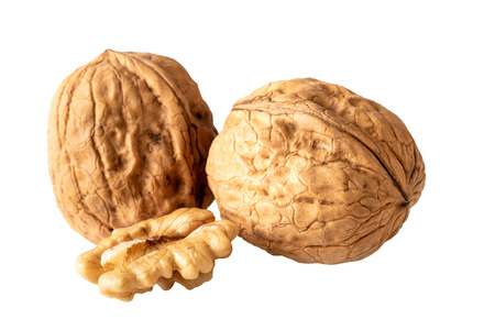 two unshelled walnuts and walnut halve isolated on whiteの写真素材
