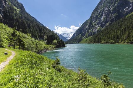 Hiking trail around mountain lake. Alps mountains, Stillup Lake, Austria, Tyrol Regionの写真素材