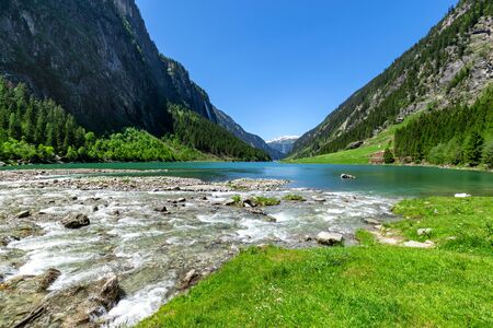 Fast water stream flow into mountain lake. Summer mountain landscape in the Alps, Austria, Tyrol.の写真素材