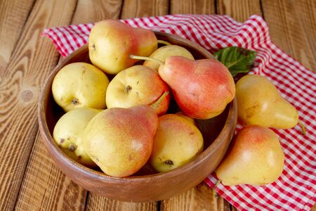 Autumn still life. Pear fruit on wooden table with red checkered tablecloth. Rustic design.の写真素材