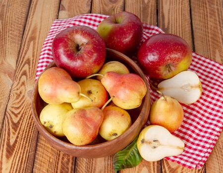 Autumn still life. Pear and apple on wooden table with red checkered tablecloth. Pears and apples flat lay overhead.の写真素材