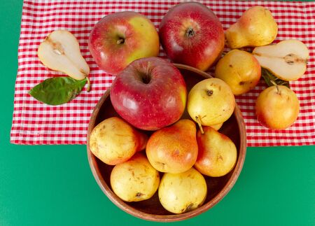 Autumn still life. Pear and apple on green table with red checkered tablecloth. Rustic design.の写真素材