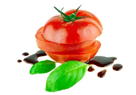 Tomato slices with balsamic vinegar drops and basil leafの写真素材